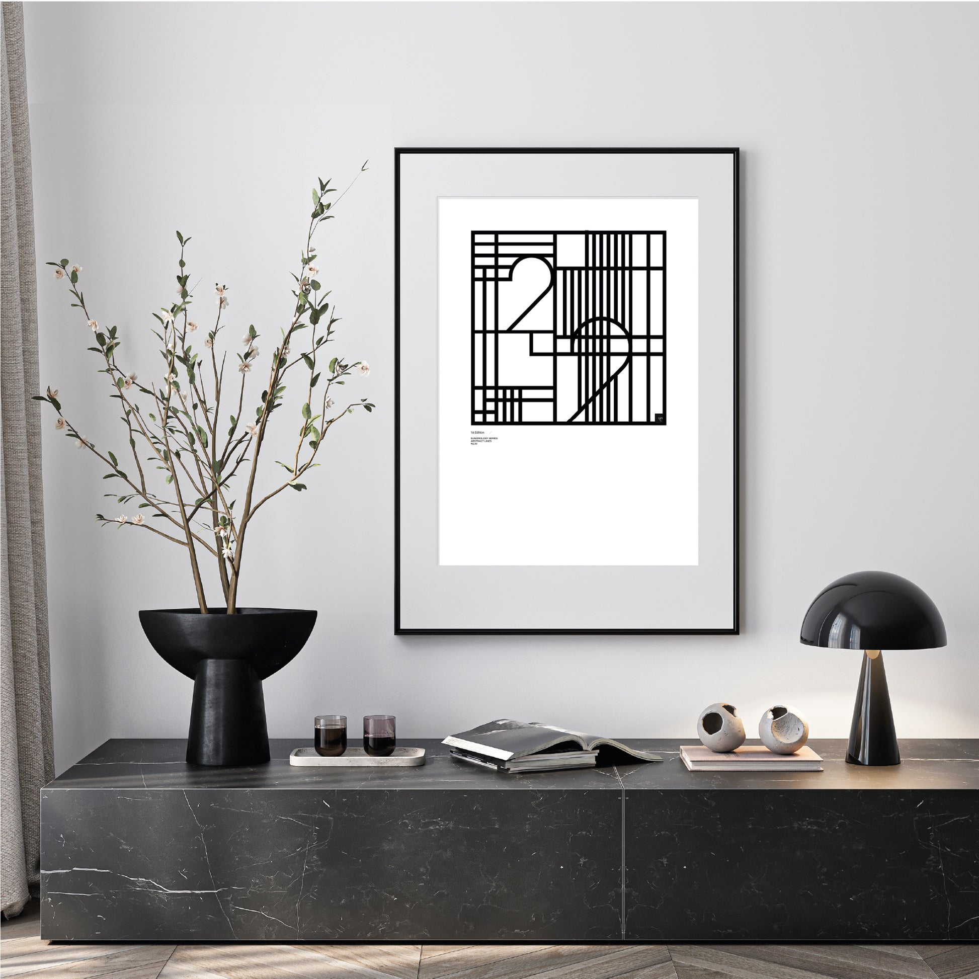 Modern interior with a black and white numerology number 22 framed, limited edition abstract art print on a gray wall.
