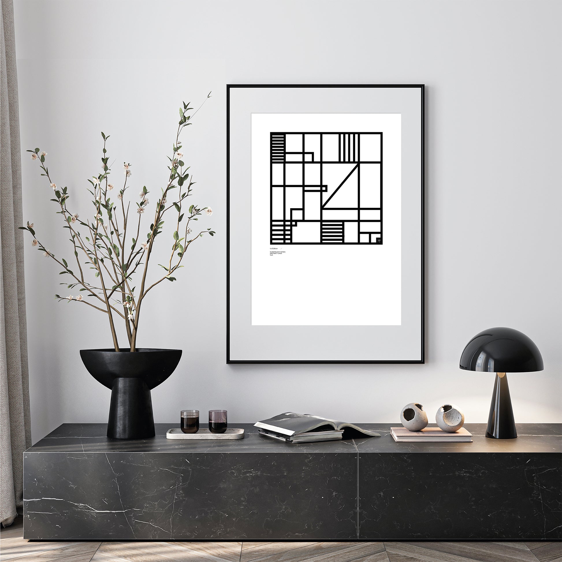 Modern interior with a black and white framed Numerology No.4 abstract Limited Edition print on a wall, a vase with branches, and decorative items on a console table. 